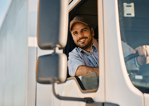 smiling truck driver in vehicle promoting delivery services for eight loads